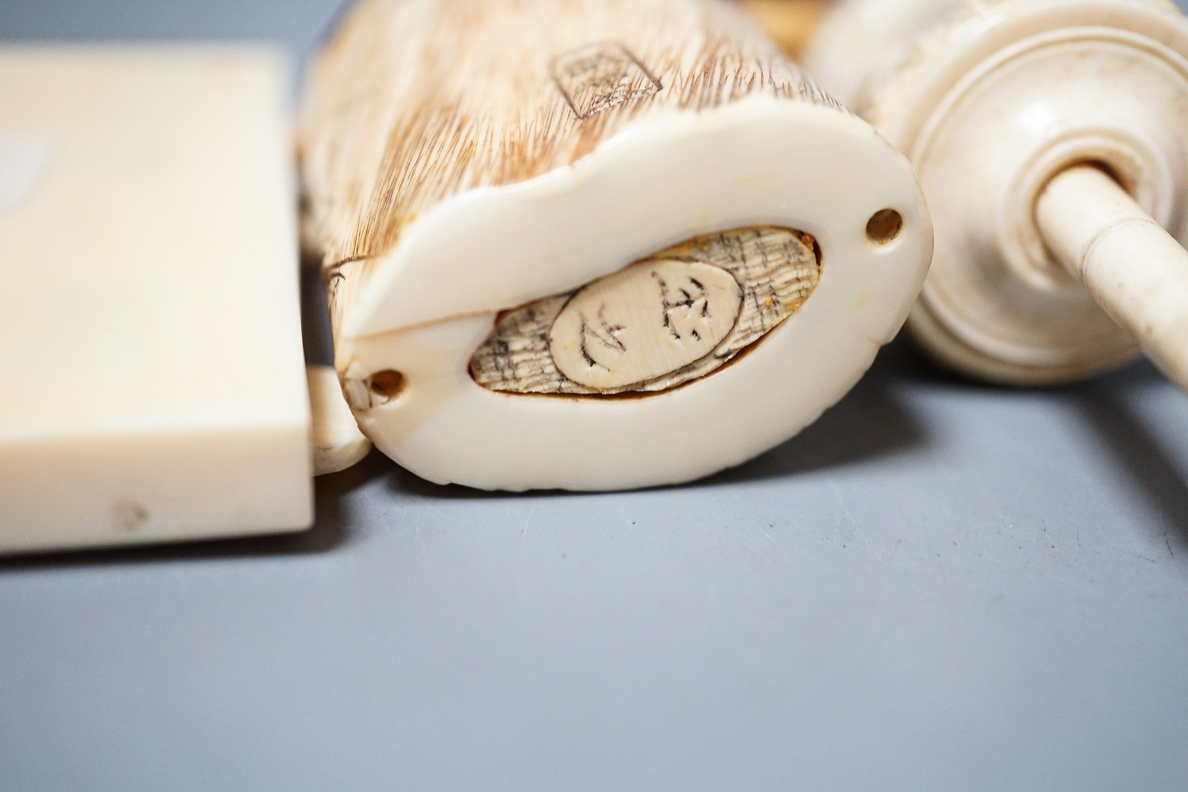 Three Japanese Ivory figures of men, a similar bezique marker, a Japanese staghorn single section inro with ivory manju, a Chinese ivory carving and a bone needlework container